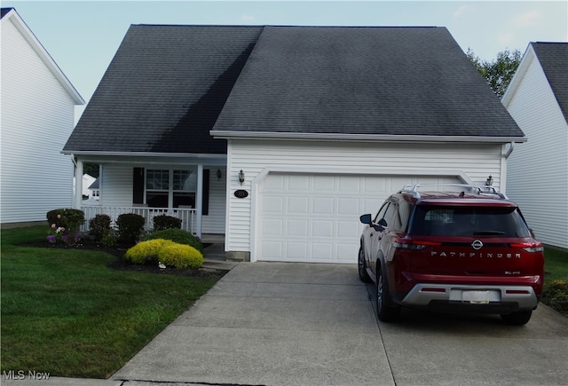 view of front of property featuring a garage, a front lawn, and a porch