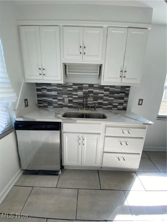 kitchen featuring dishwasher, backsplash, sink, light tile patterned flooring, and white cabinetry