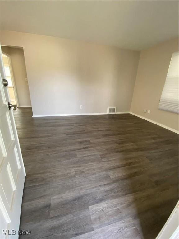 unfurnished room featuring dark wood-type flooring