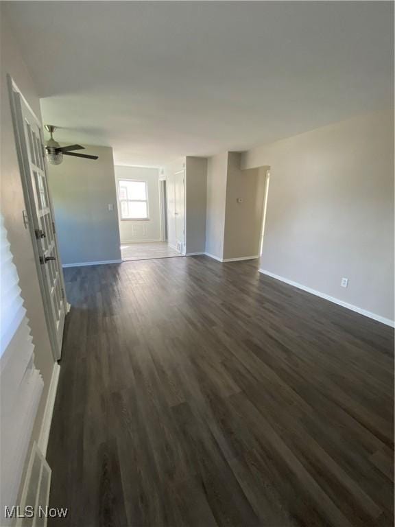 empty room featuring ceiling fan and dark wood-type flooring