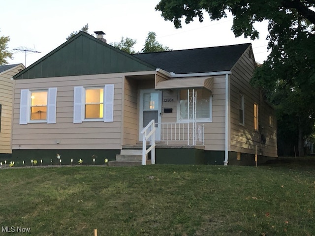 view of front of house with covered porch and a front lawn