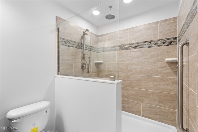 bathroom with toilet and a tile shower