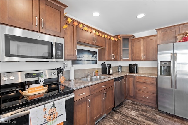 kitchen with light stone countertops, stainless steel appliances, dark hardwood / wood-style floors, and sink