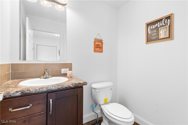 bathroom with vanity, backsplash, and toilet