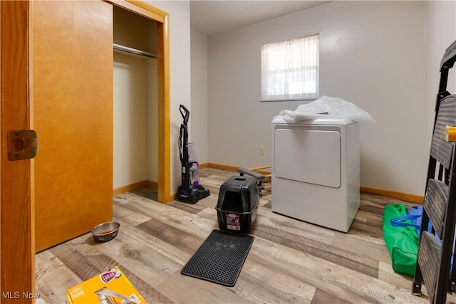 clothes washing area featuring light hardwood / wood-style floors and washing machine and clothes dryer