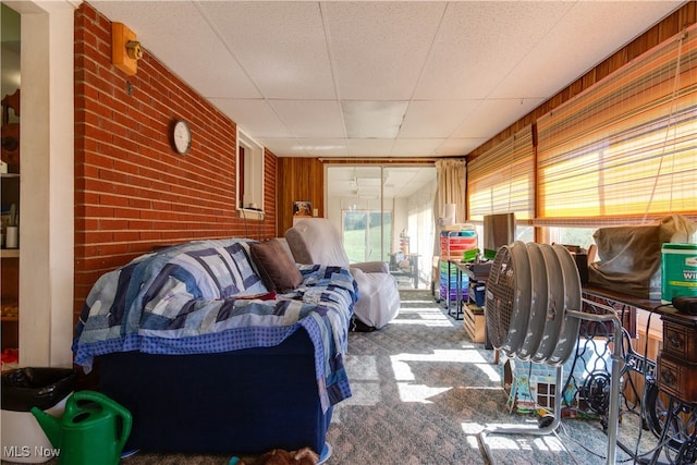 carpeted living room featuring wooden walls