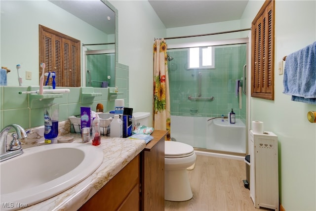 bathroom with wood-type flooring, a shower with curtain, vanity, and toilet