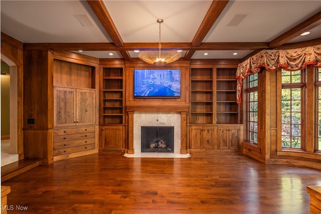 unfurnished living room with beamed ceiling, a healthy amount of sunlight, and dark hardwood / wood-style flooring