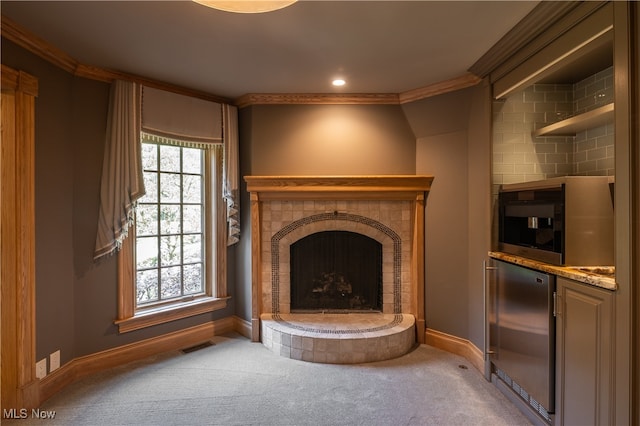 unfurnished living room featuring carpet floors, crown molding, and a tile fireplace