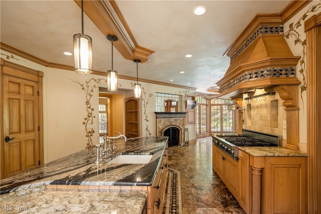 kitchen featuring stainless steel gas stovetop, pendant lighting, sink, and a wealth of natural light