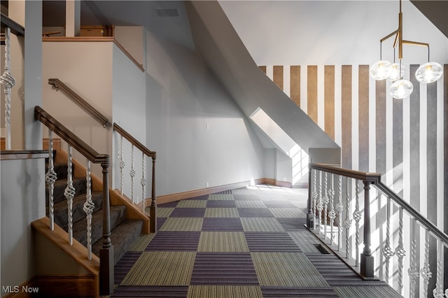 interior space with a towering ceiling, a chandelier, and carpet