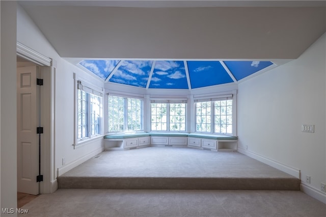 interior space featuring a healthy amount of sunlight, lofted ceiling, and light carpet