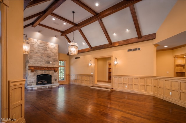 unfurnished living room with a fireplace, beam ceiling, hardwood / wood-style floors, and high vaulted ceiling