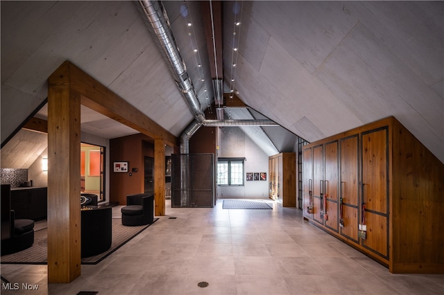 additional living space with vaulted ceiling with beams and wood walls