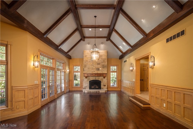 unfurnished living room featuring high vaulted ceiling, beamed ceiling, dark wood-type flooring, and a stone fireplace