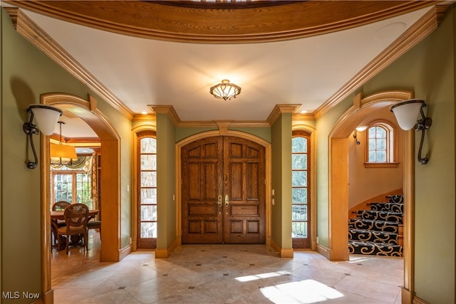 foyer featuring an inviting chandelier and ornamental molding