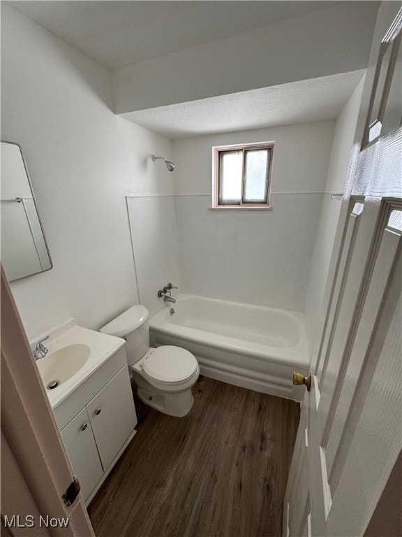 full bathroom featuring vanity, bathtub / shower combination, a textured ceiling, hardwood / wood-style flooring, and toilet