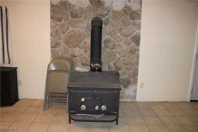 details with a wood stove and tile patterned floors