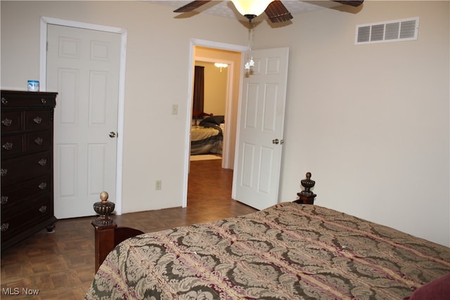 bedroom with beam ceiling, ceiling fan, and dark parquet flooring