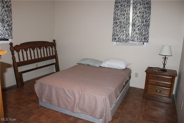 bedroom featuring dark parquet flooring