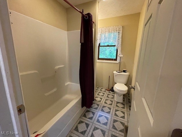 bathroom with a textured ceiling, shower / tub combo with curtain, and toilet