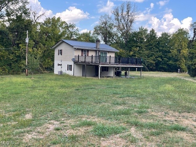 rear view of house featuring a yard and a wooden deck