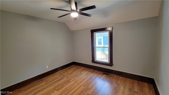 spare room with ceiling fan, vaulted ceiling, and light hardwood / wood-style floors