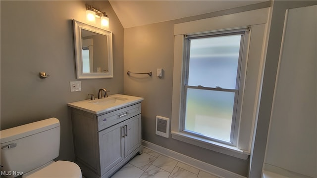 bathroom with vanity, lofted ceiling, heating unit, and toilet