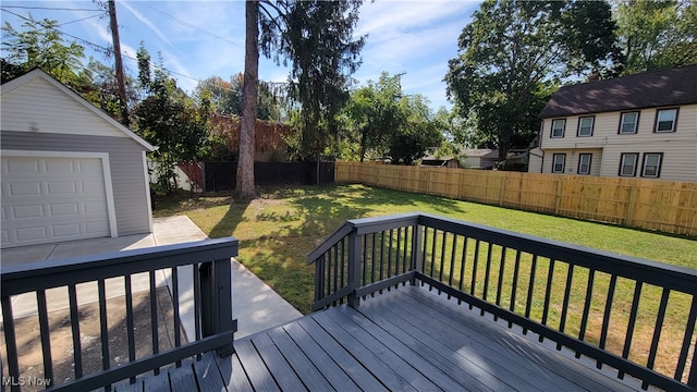 wooden deck with a garage, an outdoor structure, and a lawn