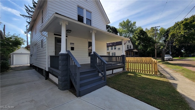 view of front of property with an outbuilding, a garage, a front yard, and covered porch