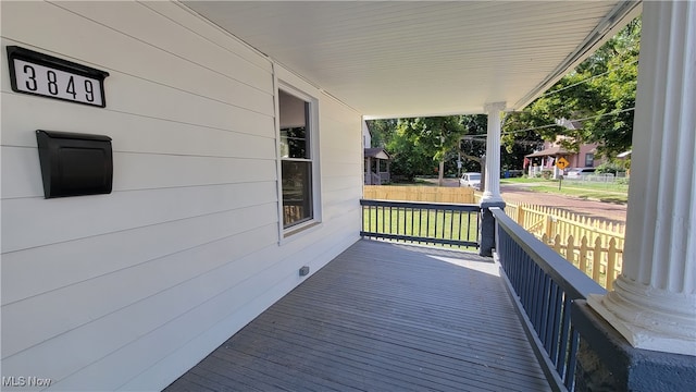 wooden terrace with a porch and a yard