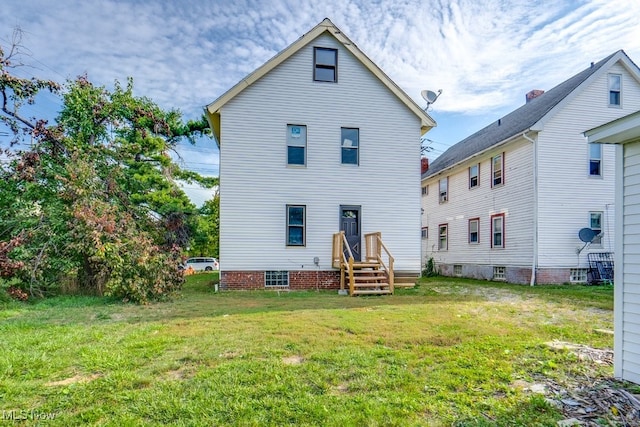 rear view of property featuring a lawn