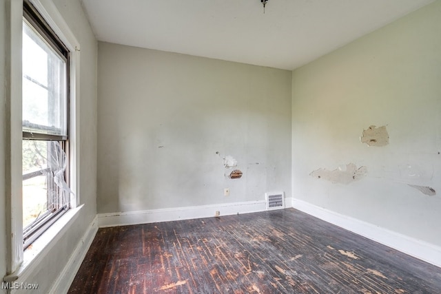 empty room featuring dark hardwood / wood-style flooring and plenty of natural light