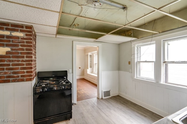 kitchen featuring black range with gas cooktop and hardwood / wood-style flooring