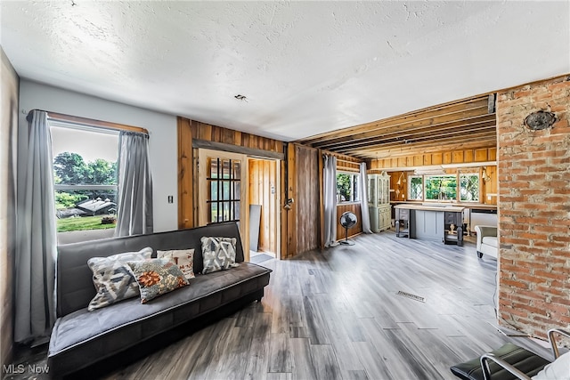 sitting room featuring wood-type flooring, a textured ceiling, and wooden walls