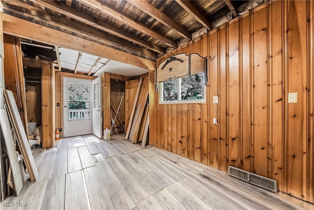 misc room with beamed ceiling, wooden walls, light wood-type flooring, and wood ceiling