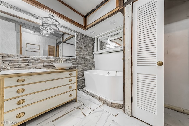 bathroom featuring vanity, a bathing tub, and ornamental molding