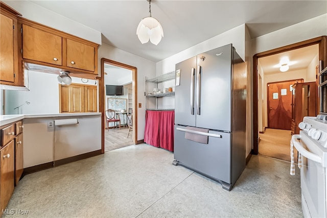 kitchen featuring decorative light fixtures, stainless steel fridge, and electric range