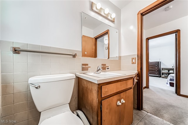 bathroom featuring tile walls, vanity, and toilet