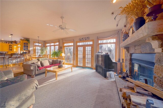 10000 Wisner Rd, Chardon, OH 44024 - living room with light carpet, french doors, a ceiling fan, and a stone fireplace