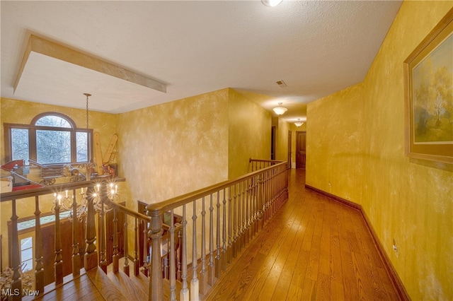 corridor featuring hardwood / wood-style flooring and a textured ceiling