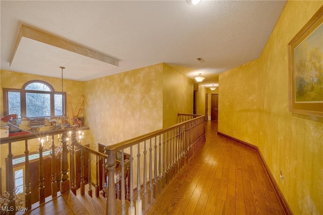 10000 Wisner Rd, Chardon, OH 44024 - hallway with visible vents, baseboards, an upstairs landing, and hardwood / wood-style flooring