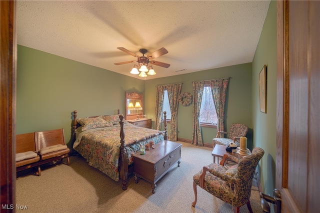 bedroom with a textured ceiling, ceiling fan, and light colored carpet