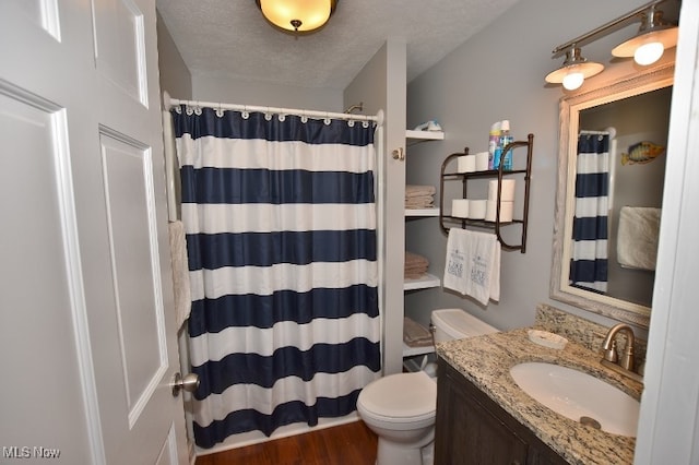 bathroom with curtained shower, vanity, a textured ceiling, hardwood / wood-style flooring, and toilet