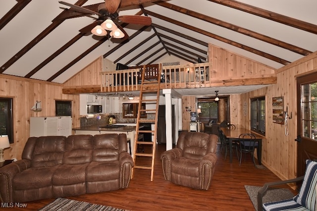 living room featuring hardwood / wood-style flooring, beam ceiling, high vaulted ceiling, wooden walls, and ceiling fan