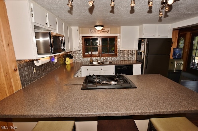 kitchen with black appliances, decorative backsplash, sink, and white cabinets