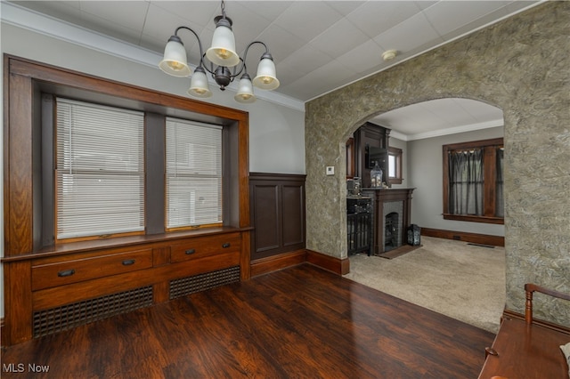 dining area with a chandelier, dark wood-type flooring, and crown molding