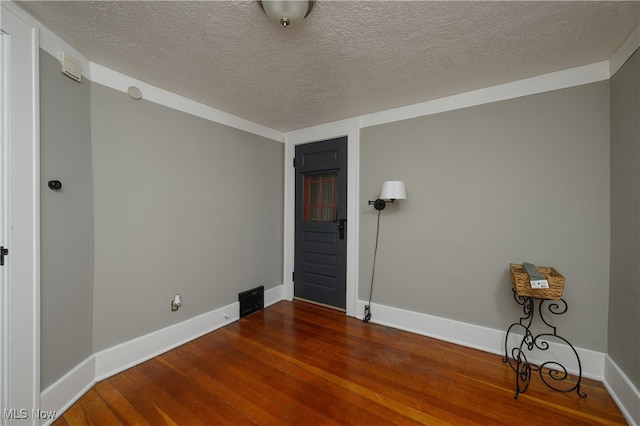 empty room with a textured ceiling and hardwood / wood-style flooring