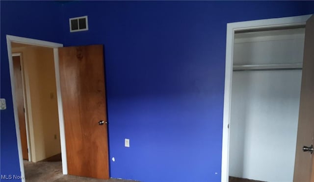 unfurnished bedroom with visible vents and a closet