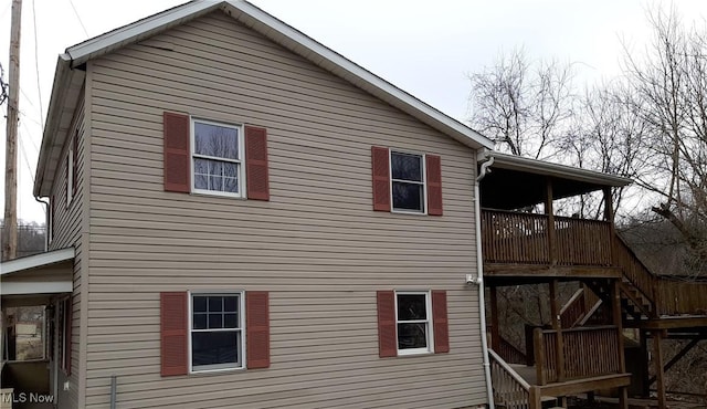 view of side of property featuring stairs and a deck